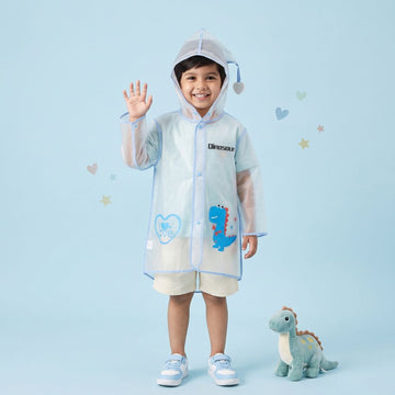 Smiling boy in transparent waterproof kids raincoat with hood