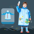 Boy wearing blue dinosaur raincoat for kids with matching rain boots