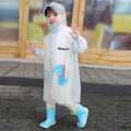 Boy outdoors in transparent blue dinosaur raincoat and rain boots